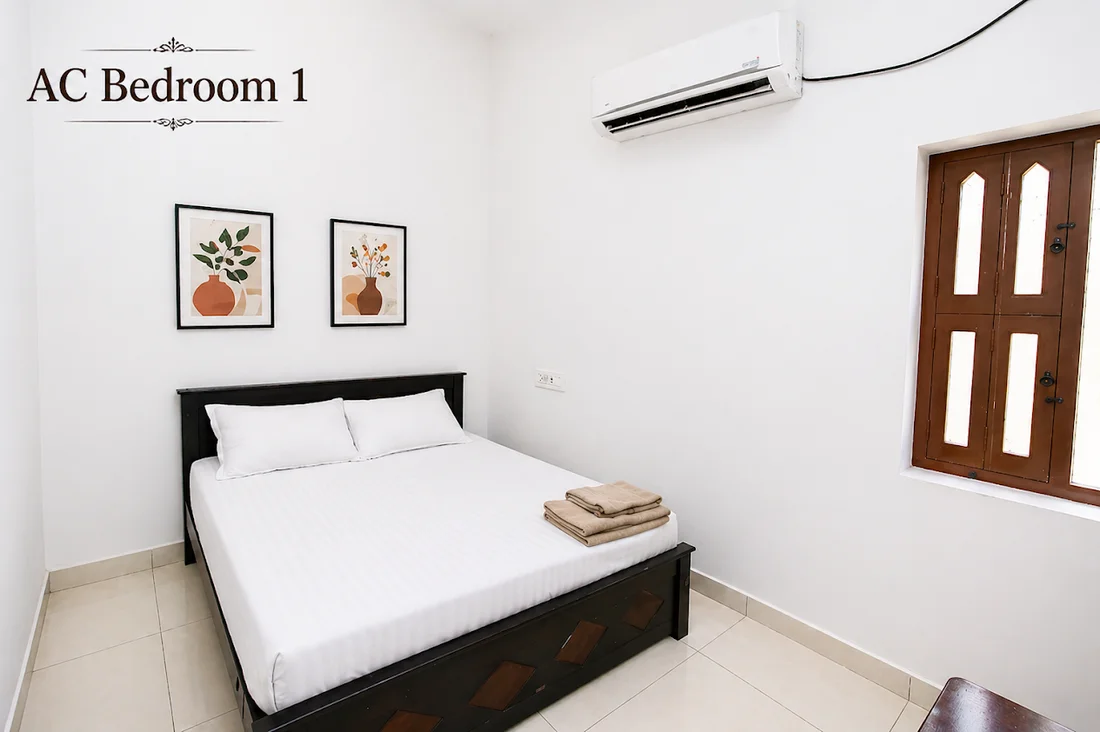 AC Bedroom 1 with a double bed, fresh linen and wall art