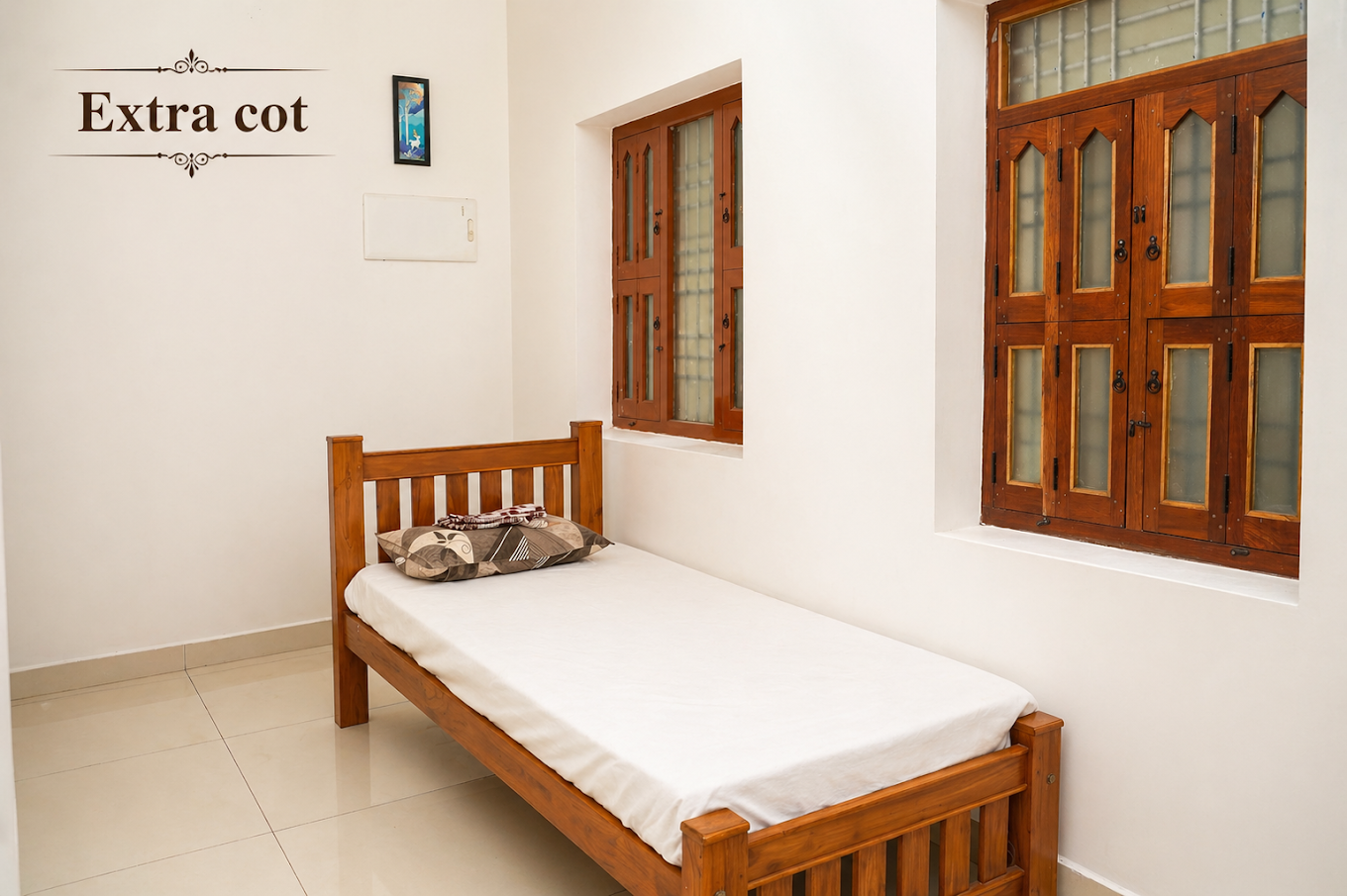 Extra single cot beside wooden windows