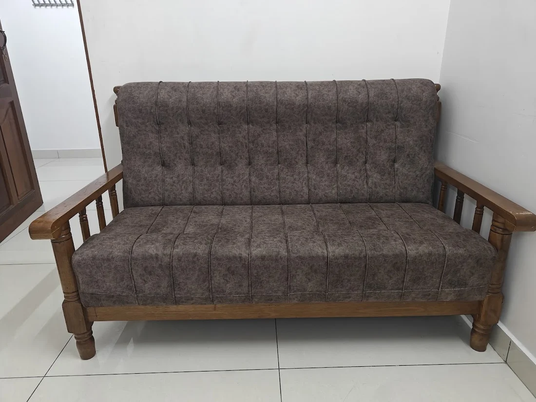 Wooden-frame sofa with patterned brown cushions in the sitting area